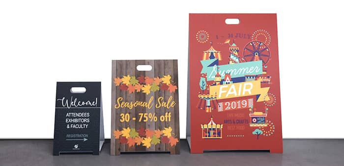 3 coroplast a frame signs of different heights next to each other.